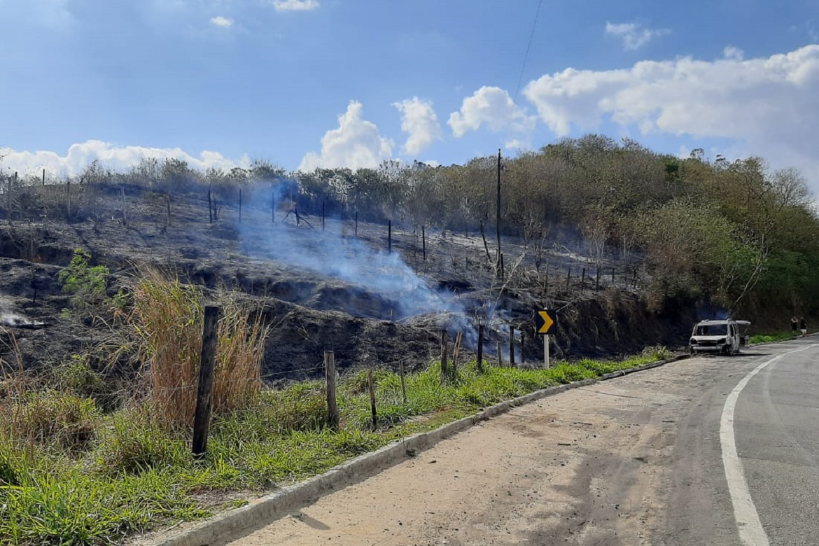  Carro pega fogo às margens de estrada e chamas se espalham pela vegetação